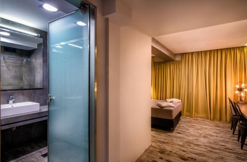 雅典360度酒店的带淋浴和盥洗盆的浴室以及1张床。