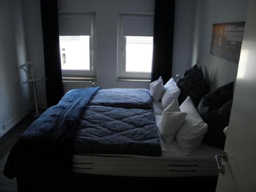 费尔登Altstadtwohnung的一间卧室配有一张带蓝色毯子的床和两个窗户。