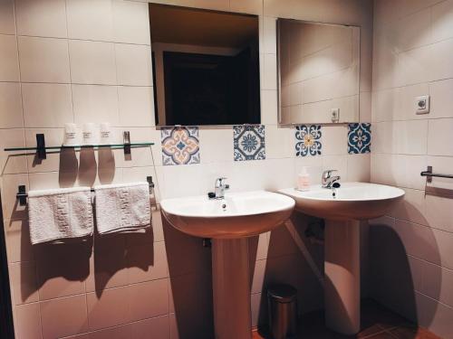 El CastellarHotel Rural Curia的浴室设有2个水槽、镜子和毛巾。