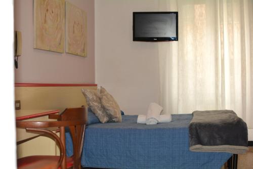 瓦拉泽HOTEL LA MADUNINA的卧室配有一张床铺,墙上配有电视