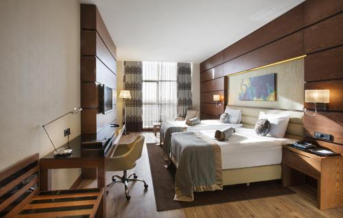 埃尔比勒埃尔比勒市中心德德曼酒店的酒店客房配有两张床和一张书桌
