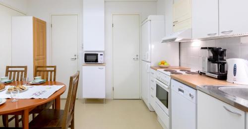 KauhajokiHostel Eduskunta的厨房配有白色橱柜、木桌和用餐室