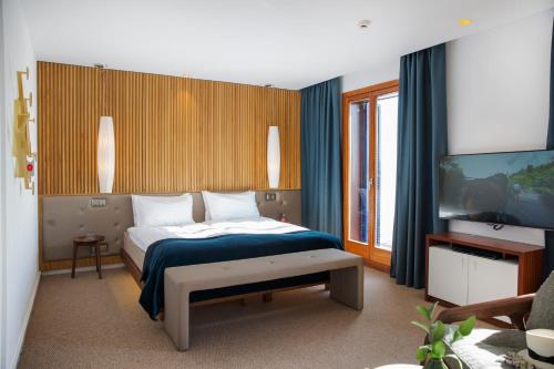 马略卡岛帕尔马博尔题索尔酒店＆餐厅的一间卧室配有一张床,并在一间客房内配有电视。