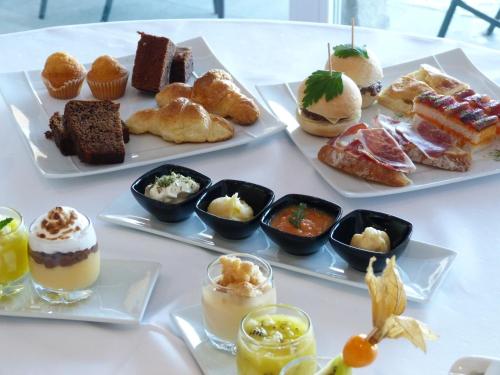 霍约斯德尔埃斯皮诺米兰皇家酒店的一张桌子,上面放着几盘糕点和甜点