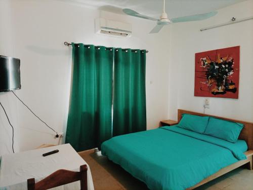 科托努Le Hublot的一间卧室配有绿色的床和绿色窗帘