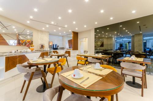 里斯本杜阿斯纳克斯酒店的餐厅设有木桌、椅子和柜台