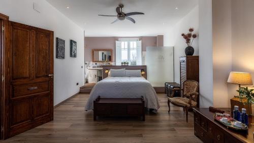 萨拉戈萨Finca Almenara de Copau的卧室配有1张床、1张桌子和1把椅子