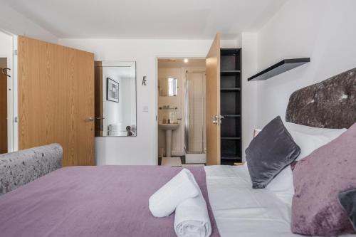 罗姆福特Beautiful 3-Bed Apartment in Romford的一间卧室配有一张带紫色床单和枕头的床。