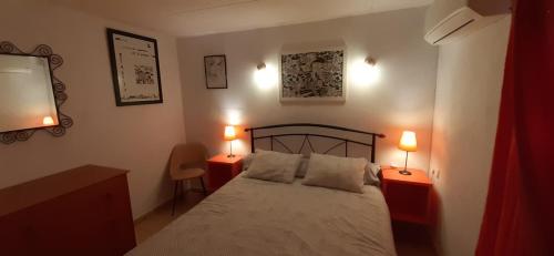 PauAppartement & Spa - Panoramic Olivars的一间卧室配有一张床和两张台灯。