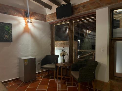 莱瓦镇Hotel, Bungalows, Chalet y Cabañas Aventura Park Villa De Leyva La Periquera的客房设有桌椅和窗户。