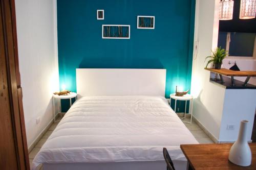 都灵Carducci green - Appartamento monolocale的卧室配有白色的床和蓝色的墙壁