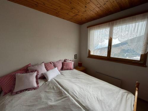 阿尔宾内Gemütliche Wohnung mit Traumaussicht!的一间卧室配有带粉色和白色枕头的床