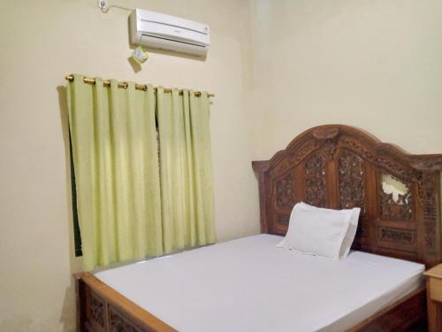 Kota Bawah TimurDeeva Homestay Syariah RedPartner的一间卧室配有一张带绿帘的床
