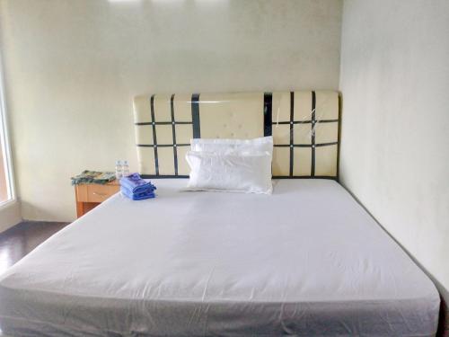 Kota Bawah TimurDeeva Homestay Syariah RedPartner的一张大床,放在一个枕头上的房间