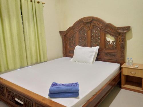 Kota Bawah TimurDeeva Homestay Syariah RedPartner的一间卧室配有一张带蓝色毛巾的木床