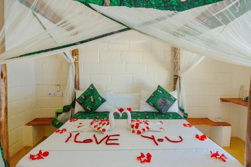 肯杜瓦Tropicana Garden的一间卧室,床上写着爱的床