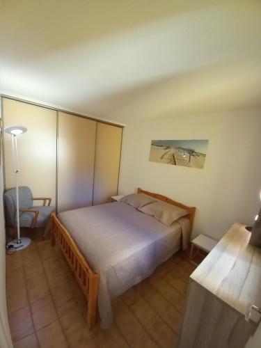 阿格德角Hélios 24, T2 climatisé, parking, terrasse, 500m plage的一间卧室配有一张大床和一张书桌
