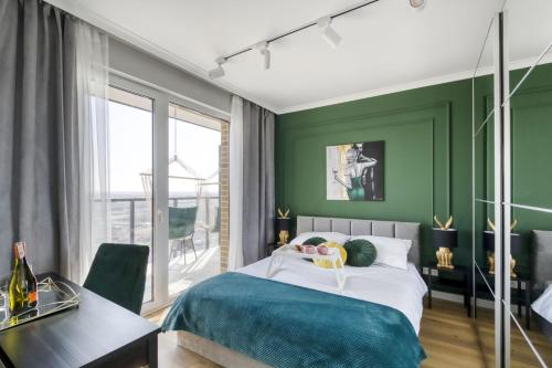 华沙Horyzont 115的一间卧室设有绿色的墙壁、一张床和一张书桌