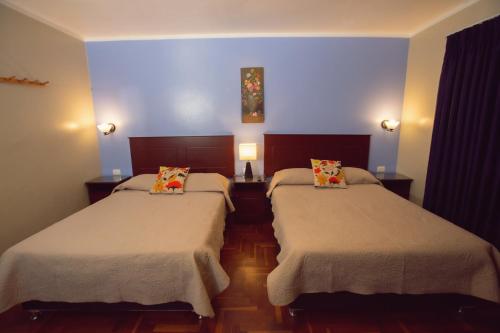 阿亚库乔Hospedaje Zaragoza的蓝色墙壁客房的两张床