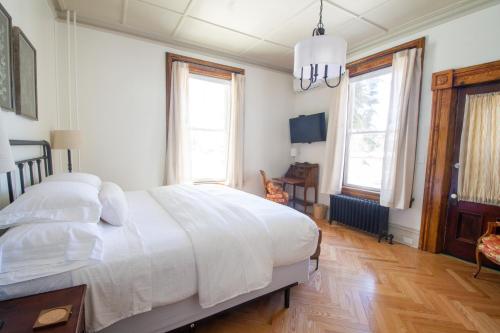 波茨坦Pert House的卧室设有白色大床和窗户。