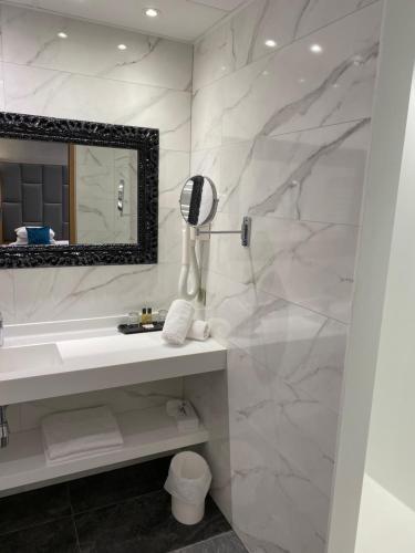 米卢斯布里斯托酒店的白色的浴室设有水槽和镜子