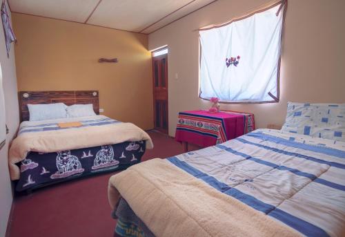 LlachonPosada de Oliver的一间卧室配有两张床,窗户配有行李箱