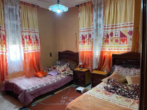 艾兹鲁Cozy Home in Azrou的一间卧室设有两张单人床和窗帘
