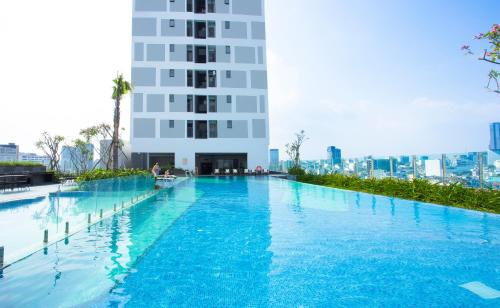 胡志明市Oui! Oui! Saigon Apartment - Rivergate Residence的一座高楼前的大型游泳池