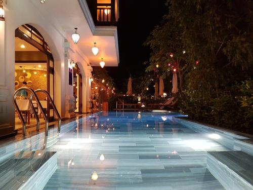 会安Hoi An Odyssey Hotel & Spa的一座建筑物中间的游泳池
