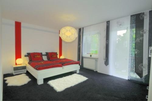 GeroldsgrünFerienwohnung Jessica的一间卧室配有红色枕头的床