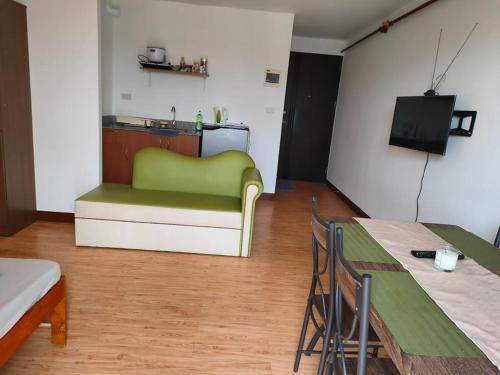 达沃市HUGE STUDIO @ Arezzo place Davao condominium的客厅配有绿色沙发和桌子