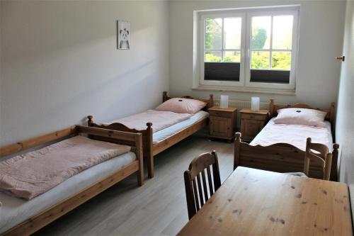 格洛米茨"Pappelhof - Whg 2"的客房设有两张床、一张桌子和一扇窗户。
