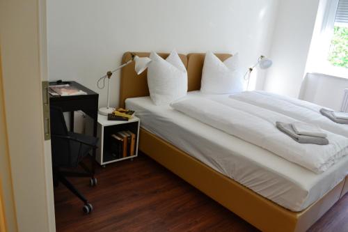 阿诺尔德施泰因洛克赛德公寓的一间卧室配有一张带书桌的床和窗户。
