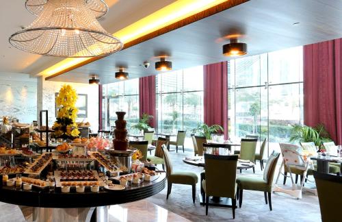 迪拜voco - Bonnington Dubai, an IHG Hotel的用餐室设有桌椅和窗户。
