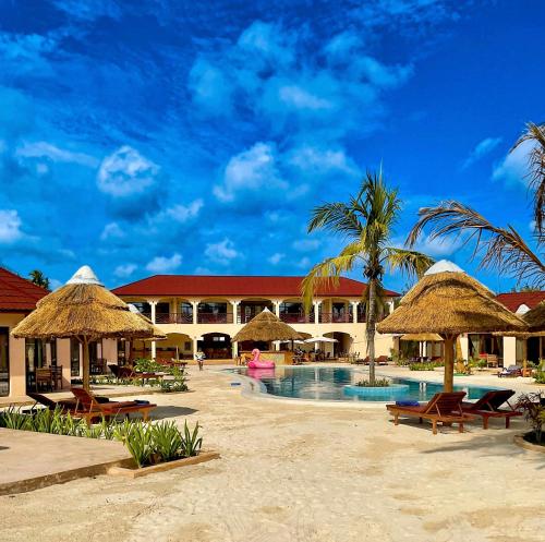 帕杰Paje Blu Boutique Hotel的一个带游泳池和稻草遮阳伞的度假村