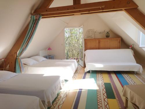 武夫赖La Tonnelle de Vouvray的阁楼卧室设有两张床和窗户。