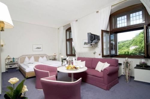 贝尔吉施格拉德巴赫马特森库姆图瑞餐厅&酒店的客厅配有紫色沙发和桌子