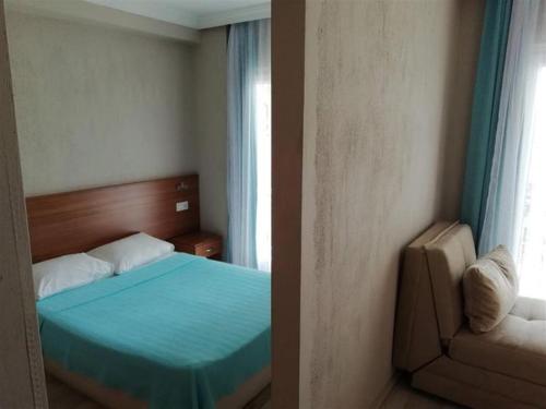 锡德Dolunaydın Butik Otel的一间卧室设有蓝色的床和窗户。