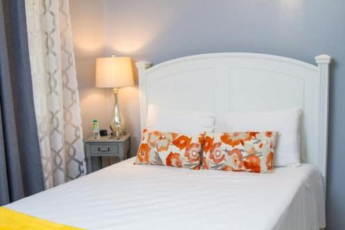RichmondVillas Richmond Estate - Ocho Rios的一张带枕头的白色床和一张桌子上的灯