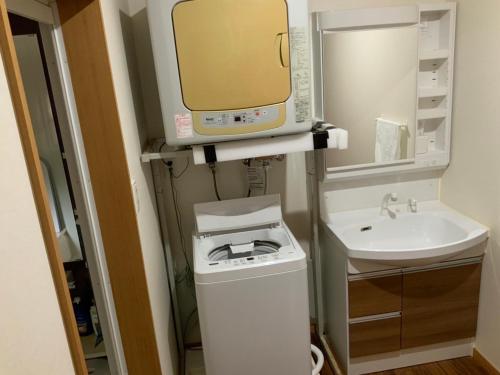 奄美AZ Hotel in Amami - Villa with private outdoor Jacuzzi的一间带水槽和微波炉的小浴室