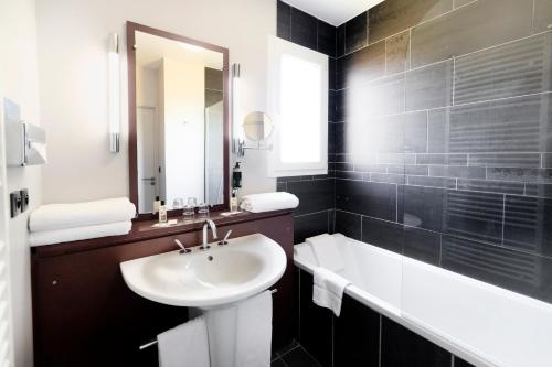佩里纳特·莱斯·萨尔列夫吉尔格维贝斯特维斯特优质酒店的黑白浴室设有水槽和浴缸。