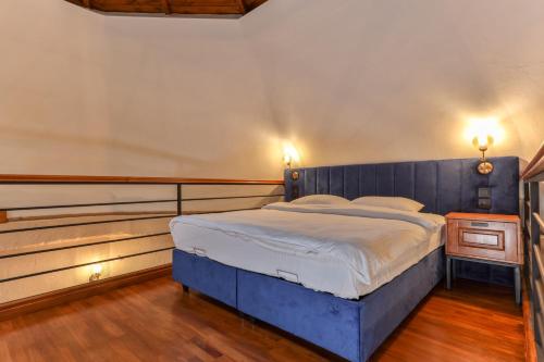 契拉勒Azur Hotel的一间卧室配有一张蓝色的床和木制床头板