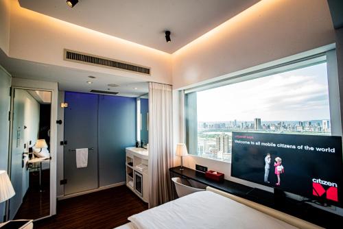 台北台北北门世民酒店的卧室设有大窗户,享有城市美景。