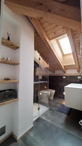 摩德纳迪-坎皮格里奥Mansarda la Baita的浴室拥有白色的墙壁和带天窗的天花板。