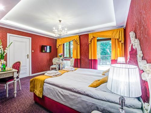 萨诺克ROYAL PALACE Centrum Bankietowe的一间卧室设有一张带红色墙壁的大床