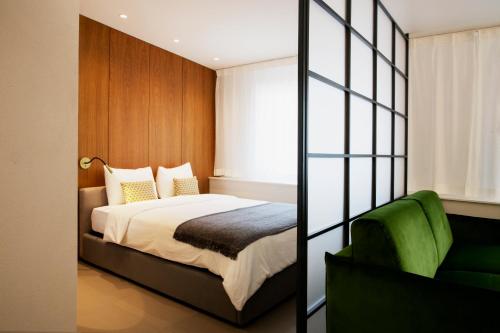 伊韦尔东Vigata的一间卧室配有一张床和一把绿色椅子