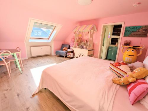 盖尔森基兴Candypartment Sweets 'n Sleep的粉红色的卧室配有一张大床和小猫枕头