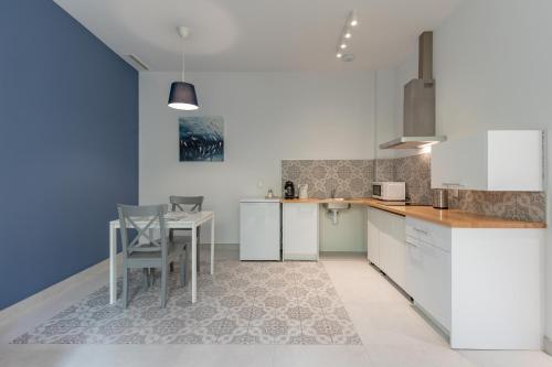 瓦伦西亚Sunny,Private Terrace,Wheelchair access的厨房配有白色橱柜和桌椅