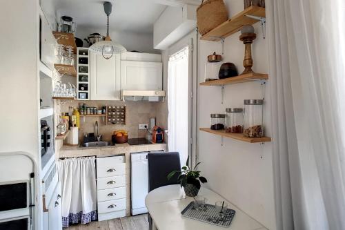 戛纳HENRI CAMILLE REAL ESTATE - CARNOT - Nice studio 8min Palais的小厨房配有白色橱柜和桌子