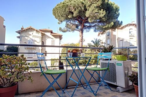 戛纳HENRI CAMILLE REAL ESTATE - CARNOT - Nice studio 8min Palais的阳台配有两把椅子和一棵树